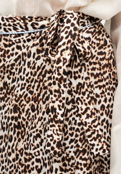 Φούστα τύπου wrap με λεοπάρ σχέδιο, με βάση σε ταμπά χρώμα και σκούρα καφέ κηλίδες, δεμένη στη μέση με ζώνη από το ίδιο ύφασμα. Απαλό, ελαφρύ υλικό.