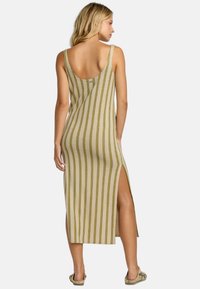 Vestido maxi de punto con escote en la espalda, patrón a rayas en beige y verde, abertura lateral y tirantes anchos. Ideal para el clima cálido.