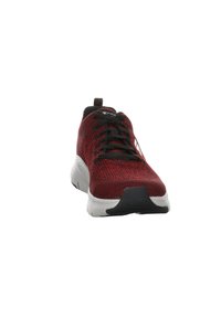 Scarpe da ginnastica rosse e nere con tomaia in maglia traspirante, superficie testurizzata, intersuola bianca e suola esterna in gomma nera. Presentano una chiusura con lacci.