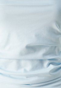 Šviesiai mėlyna, minkšta medvilnės medžiaga su lygiu paviršiumi ir subtiliu drapavimu. Pasižymi lengvais raukšlėmis ir susikaupimais, suteikiančiais sklindančio išvaizdą.