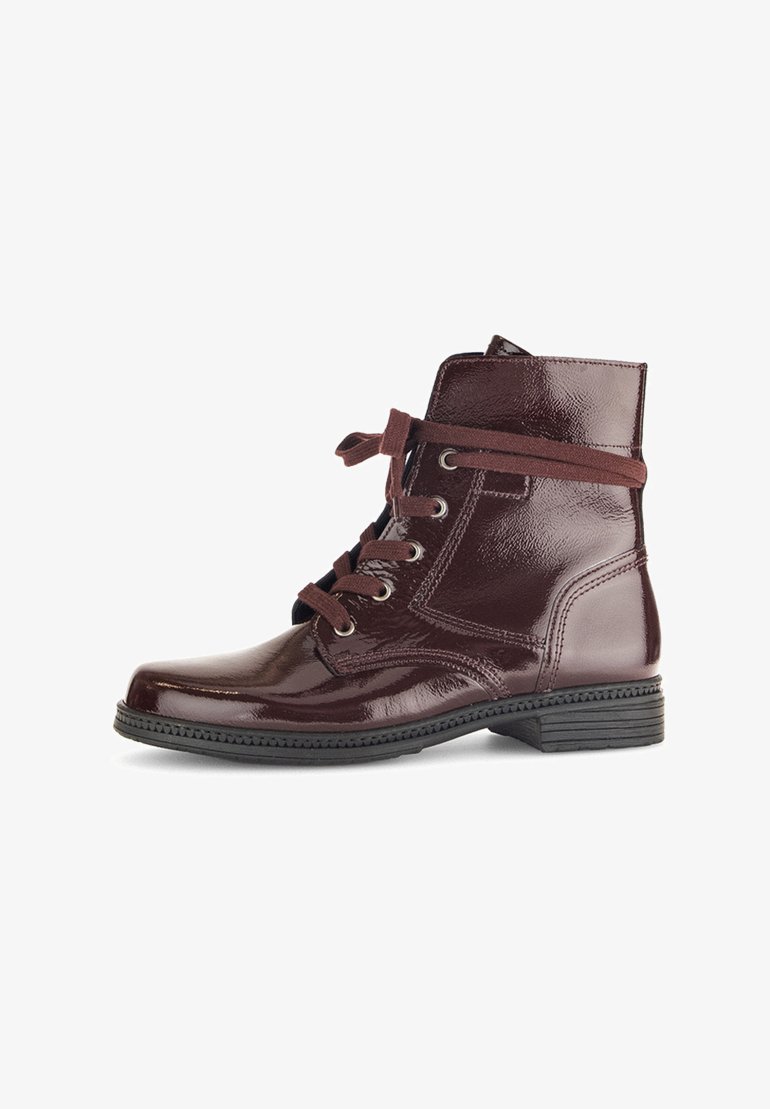 Bottines à lacets en vernis bordeaux, à bout rond, avec des lacets contrastés et des coutures latérales. Talon carré et semelle en caoutchouc texturé.