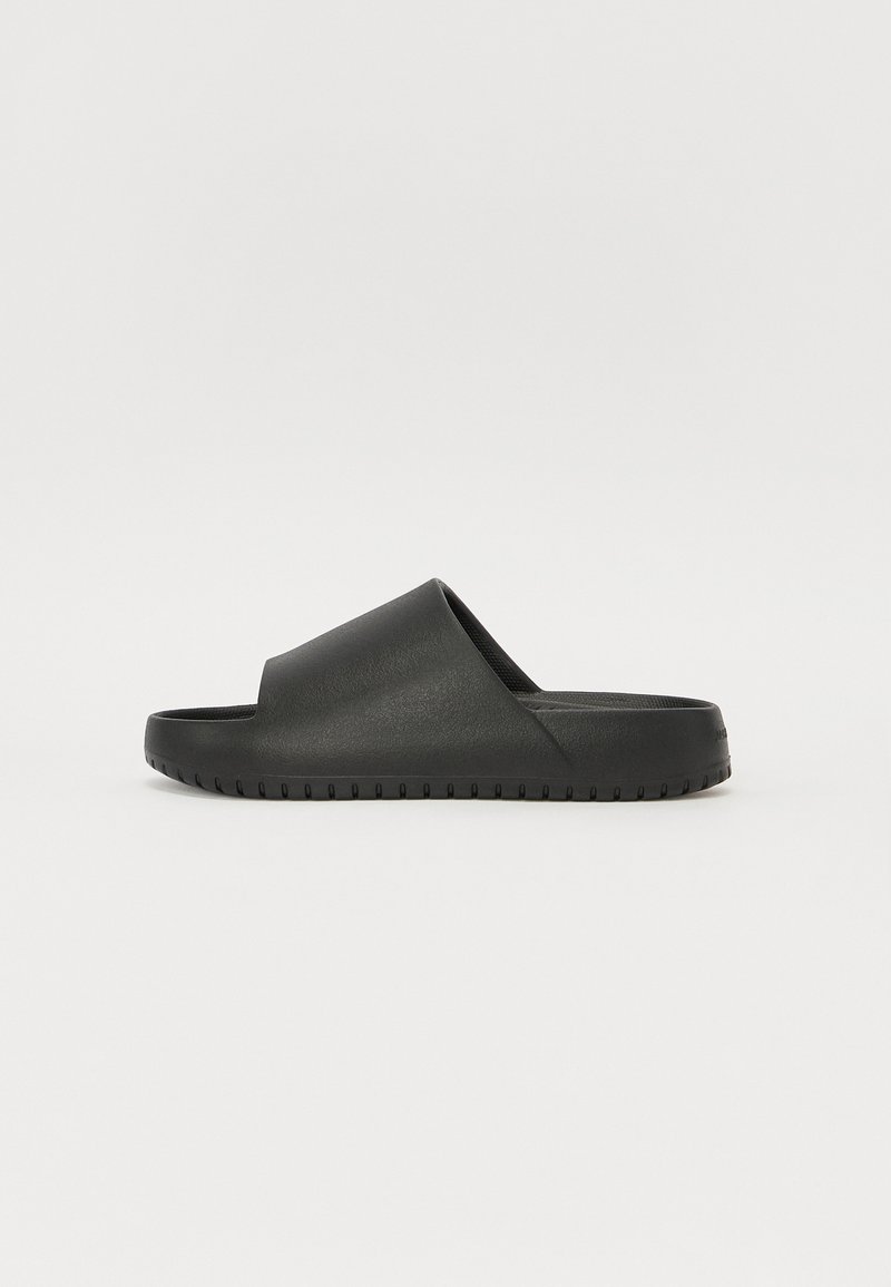 Black slide sandal featuring a smooth, matte finish, open toe, and a textured sole with horizontal grooves for traction.