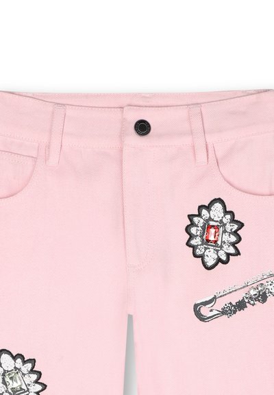 Pantaloni in denim rosa con applicazioni floreali decorative impreziosite da gioielli e accenti di fermagli di sicurezza. Design a cinque tasche con chiusura a bottone standard.