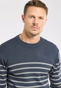 Maglione a righe blu navy realizzato in tessuto a coste, presenta righe orizzontali grigie e tre bottoni decorativi sulla spalla.