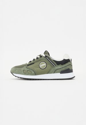 Zapatillas verdes de ante y malla con detalles en negro, suela blanca y parche de logo redondo. Presentan un diseño con cordones y detalles texturizados.