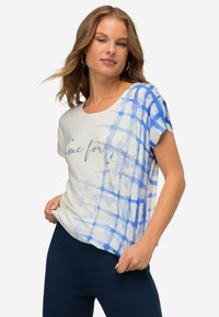 Korte ærmer T-shirt i lys creme med blåt rutemønster, med rund halsudskæring og løs pasform. Tekst trykt på forsiden.