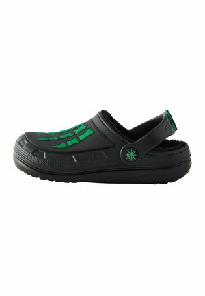 Schwarze Clogs mit grünem Skelettknochen-Design über der Oberseite, weicher Innenauskleidung, verstellbarem Rückenriemen und strukturiertem Sohle für besseren Halt.