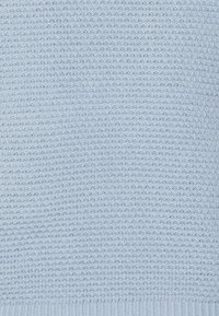 Tejido de punto azul claro con un patrón texturizado. La superficie es uniforme con un dobladillo acanalado en la parte inferior, lo que proporciona una apariencia suave.