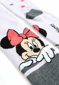 Calze a tema Minnie Mouse in tessuto lavanda, caratterizzate da un design cartoon con dettagli neri, un fiocco rosso e vivaci pois.