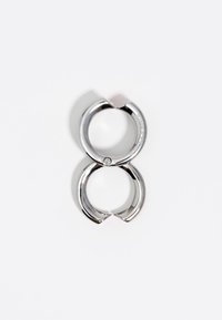 Anello a doppio cerchio in argento con una superficie liscia e lucida. Presenta una piccola pietra incastonata sul lato. Forma circolare con estremità aperte.