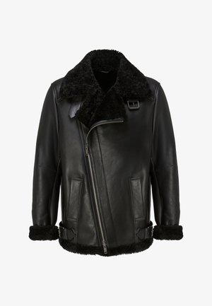 Melna ādas jaka ar vilnas apkakli, asimetrisku rāvējslēdzēju, sānu kabatām un sprādžu uzgaļiem pie aprocēm. Teksturēta virsma.