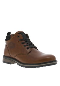 Bottine en cuir marron avec un col en tissu noir, bout rond, devant à lacets, semelle en caoutchouc et logo en relief sur le côté.