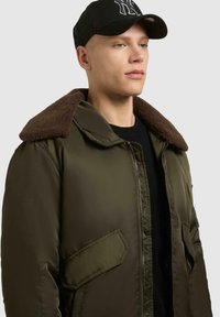 Olivgrüne Bomberjacke mit einem braunen, strukturierten Kragen. Sie verfügt über einen Reißverschluss vorne und Taschen an der Seite und besteht aus glattem, glänzendem Material.