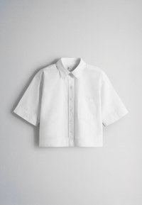 Witte kortermige blouse met knopen, kraag en borstzak, plat liggend weergegeven tegen een effen witte achtergrond.