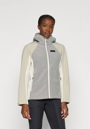 Könnyű, bézs és szürke színű zipzáras dzseki, texturált kapucnival, átlós varrásokkal és két oldalsó cipzáras zsebbel.