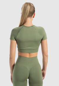 Olijfgroen sportieve crop top met korte mouwen, geribbelde textuur en naaddetails, gecombineerd met bijpassende hoog getailleerde leggings.