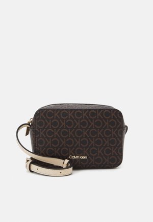 Mała prostokątna brązowa sakiewka na ramię z powtarzającym się wzorem logo CK, beżowy regulowany pasek i złote logo Calvin Klein z przodu.
