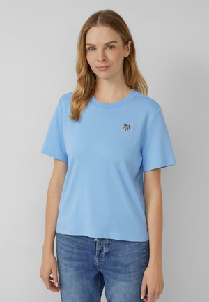 T-shirt en coton bleu clair à manches courtes, col rond, avec un petit motif de coeur noir contenant le mot "amour" à l'intérieur.