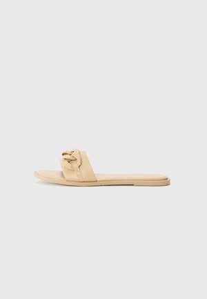 Nude slide sandals made of smooth synthetic material, featuring a knotted strap design and a flat sole, with no visible hardware or accents.
