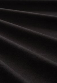 Czarna tkanina o gładkiej fakturze, z subtelnymi fałdami i falami. Materiał wydaje się gęsty i miękki, idealny do różnych zastosowań.