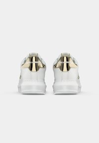 Adidași din piele albă cu accente aurii și branding pe spate. Talpă groasă din cauciuc alb și textură de suprafață netedă.