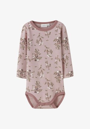 Ružičasti bebi bodi s dugim rukavima s cvjetnim uzorkom bijelih i ljubičastih cvjetova. Izrađen od mekog materijala s kopčama na dnu.