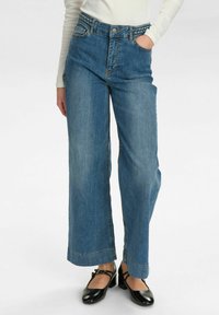Breda ben blå denimjeans med flätad midja, som har framfickor och en ren fåll. Strukturerad tyg med lätt tvättat utseende.