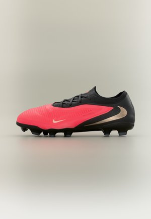 Κόκκινο και μαύρο ποδοσφαιρικό παπούτσι Nike με κορδόνια και τάπες, που παρουσιάζει πλευρική όψη σε απλό φωτεινό φόντο.