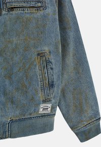 Giacca di jeans in blu chiaro con un effetto sbiadito e sottili tonalità di giallo. Presenta una tasca verticale con zip e polsini a coste. Etichetta originale visibile.
