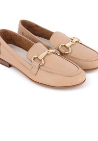 Mocasines de cuero marrón claro con un tacón bajo, que presentan un acento de hardware en tono dorado en la parte delantera y una textura interior similar al ante.