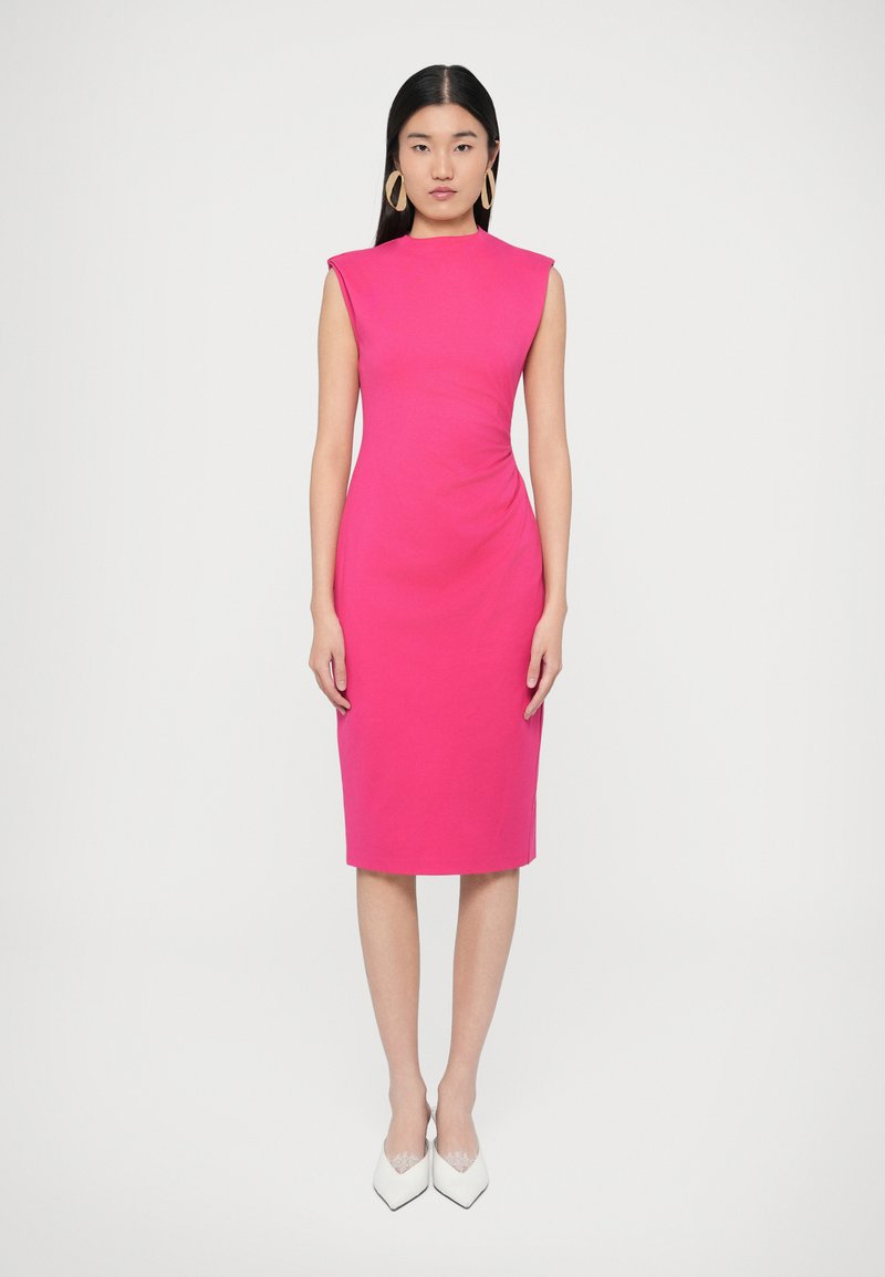 Stilīgs rozā midi kleita ar kapara piedurknēm, sānu savilkuma detaļu un gludu faktūru, kopā ar baltām kurpēm ar punktuālu purngalu.