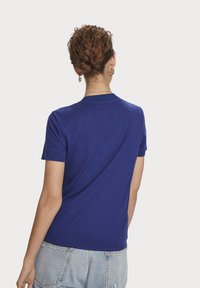 Blåt kortærmet t-shirt lavet af bomuld, med rund halsudskæring og en afslappet pasform. Stoffet har en glat overflade.