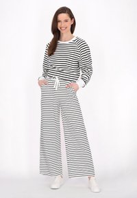 Set di abbigliamento da casa a righe bianche e nere, composto da una maglietta a maniche lunghe e pantaloni a gamba larga, realizzato in un morbido tessuto con una cintura elastica.