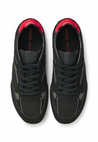 Czarne buty sportowe z siateczkową tkaniną, gumowymi podeszwami i szarymi akcentami; wyściełany czerwony kołnierz; klasyczny sznurowany fason.