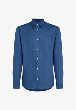 Modra dolga majica iz lanu. Ima ovratnik z gumbi, sprednji del z belo gumbom in vezeno logo na prsih.