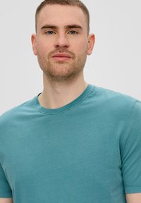 Teal katoenen t-shirt met een ronde hals en korte mouwen. Soepele textuur, casual pasvorm, geen zichtbare patronen of hardwaredetails.