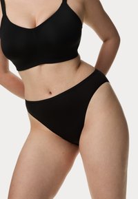 Zwarte draadloze bh en high-waisted slipset, gemaakt van gladde stof. Kenmerkt een minimalistisch ontwerp en naadloze randen voor comfort.