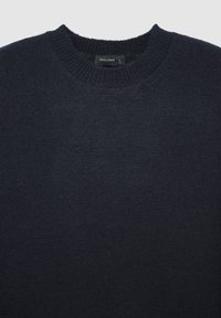 Pull en laine bleu marine foncé avec un col rond et une étiquette portant la mention "CALLIOPE L size" au col.