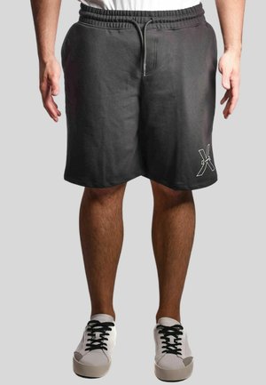 Pantaloni corti neri in cotone con vita elasticizzata e cordoncino, dotati di una tasca laterale e di un accento con logo bianco sull'orlo inferiore.