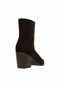 Bruine suède enklaars met een vierkante neus, gestikte details en een chunky hak. Glad van structuur met een strakke silhouet.