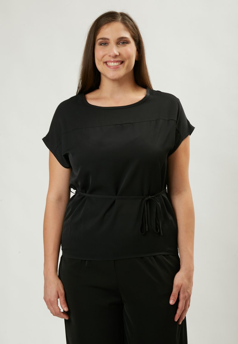 Blusa nera con maniche corte, scollatura rotonda e una cintura a cravatta in vita. Tessuto liscio e fluido con un design classico.