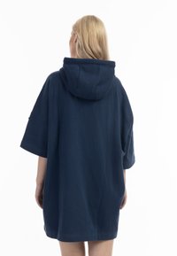 Tengerészkék, oversized kapucnis ruha, amely nagy kapucnival, rövid ujjakkal és sima textúrával rendelkezik. Minimalista dizájn, látható logók vagy minták nélkül.