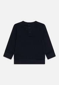 Felpa blu navy con maniche lunghe, scollo rotondo e chiusura posteriore con bottoni. Presenta polsini e orlo a coste, realizzata in tessuto morbido.