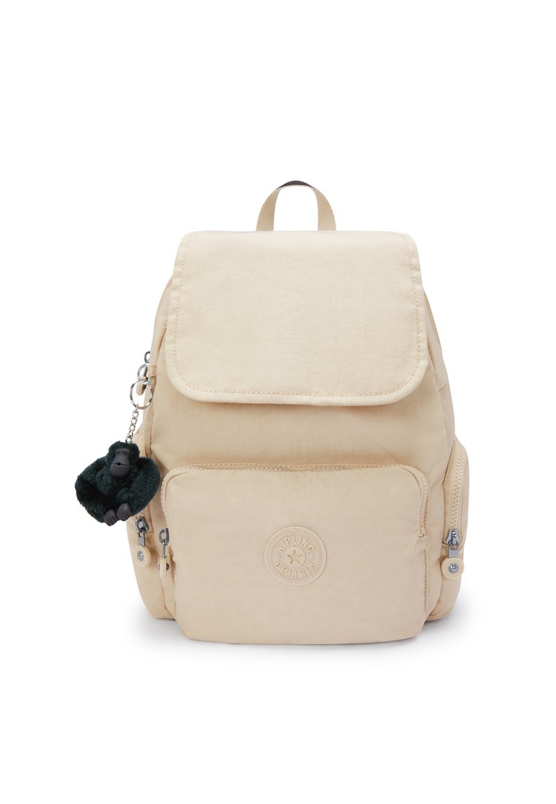 Zaino in tessuto beige con chiusura a patta, due tasche frontali con zip e un logo circolare; presenta un portachiavi a forma di scimmia pelosa verde.