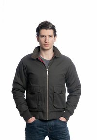 Veste bomber vert foncé en mélange de coton, avec un col en velours côtelé, une fermeture éclair à l'avant et deux poches poitrine à bouton.