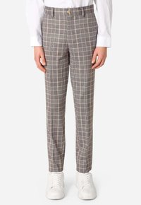 I pantaloni grigi a fantasia presentano un classico motivo a quadri con linee beige e nere. Indossati con sneakers bianche, hanno un fit su misura.
