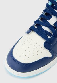 Blue leather sneaker featuring a white toe box with perforations, dark blue laces, and a light blue accent on the outsole.