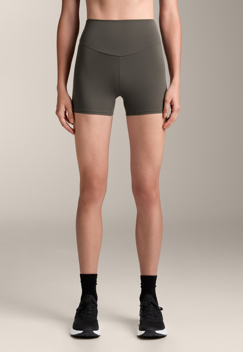 Szorty sportowe w kolorze oliwkowym, z wysokim stanem i gładką teksturą, z elastycznym paskiem do przewinięcia oraz dopasowanym krojem.