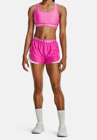 Rosa sport-bh och matchande shorts, båda med vita accenter. Bh:n har fyrkantig halsringning, och shortsen har resårmidja med logotyp.
