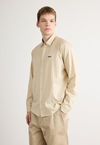 Beige, gestreepte overhemd met lange mouwen en een klassiek kraag. Het heeft een subtiele print en een zwart "BOSS" logo op de borst. Slim fit ontwerp.